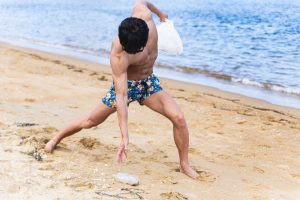 砂浜のゴミを拾うマッチョ